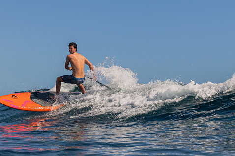 Duotone Cosmic SUP hardboard de vagues lors du SUP surf sur l'océan en orange