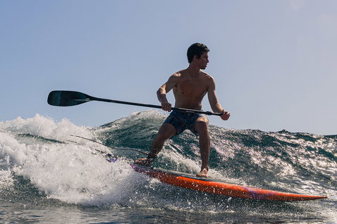 Duotone Cosmic SUP board de vague lors du surf SUP sur une vague océanique en orange