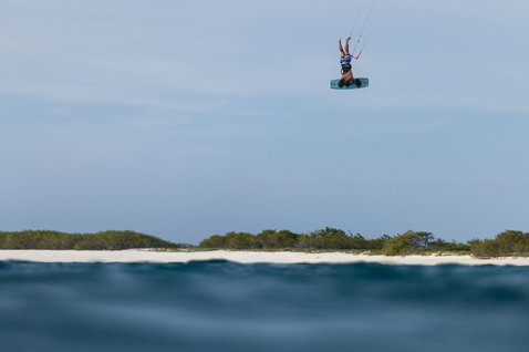 Duotone Big Air Handle en kitesurf – rider inversé en hauteur au-dessus d'une plage tropicale
