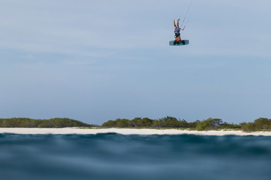 Duotone Big Air Handle en kitesurf – rider inversé en hauteur au-dessus d'une plage tropicale