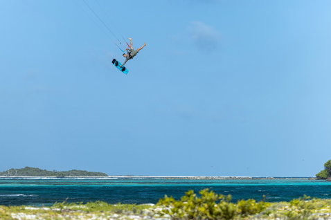 Duotone Big Air Handle lors d'un trick no-foot Big Air au-dessus d'un océan turquoise tropical