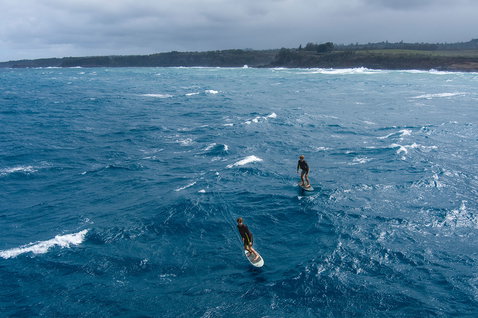 Duotone Midfish foilboard en wing foiling sur l'océan avec deux riders