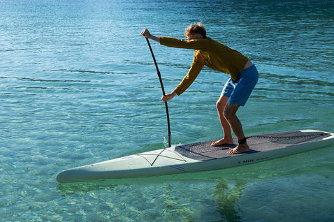 Duotone Raven planche SUP touring 12'6" en vert sauge lors d'une session paddle sur eau turquoise calme