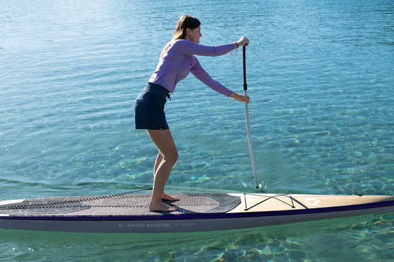 Planche SUP rigide Duotone Raven Bamboo 12'6" lors de stand-up paddle sur eau côtière turquoise