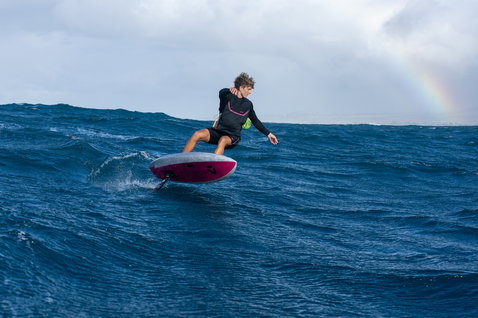 Duotone Paradox SLS planche de foil en wing foiling sur l'océan en bleu marine et magenta