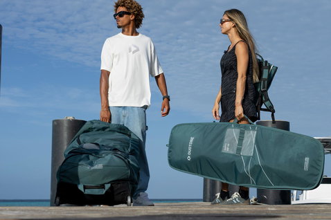 Duotone Boardbag Single Foil 127cm in dark teal carried at a marina dock