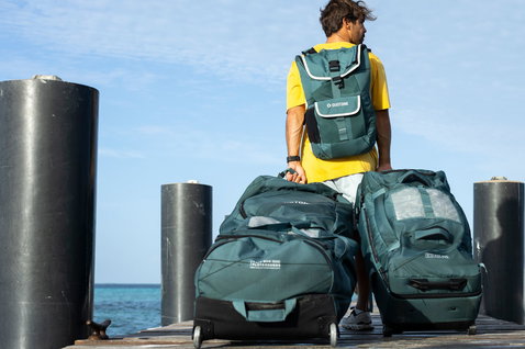 Duotone Combibag gear bag set in teal during kite travel on an ocean pier