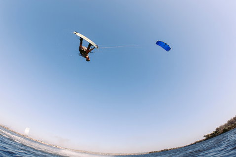 Duotone Vegas LEI Kite beim Freestyle Kitesurfen über dem Meer in blau und weiß