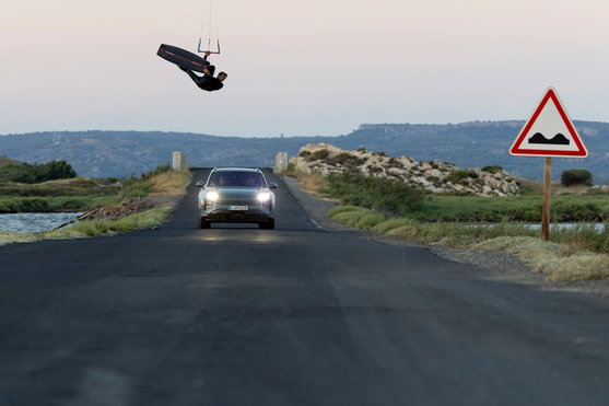 Duotone Evo SLS Porsche Edition kite LEI en kitesurf au-dessus d'une route côtière au crépuscule