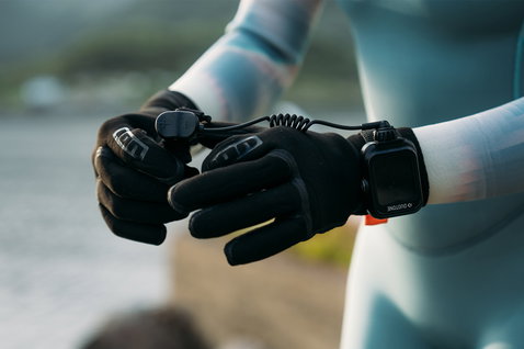 Controller Duotone Ring XL eRemote durante il foiling in riva all'acqua, indossato su mani con guanti