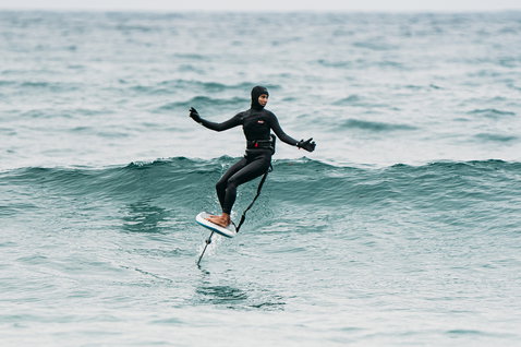 Controller Duotone Ring XL eRemote durante il foiling in mare, indossato da un rider in muta integrale
