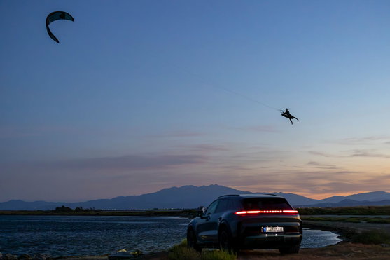 Duotone Evo SLS LEI Kite beim Kitesurfen in der Dämmerung mit Porsche Turbo an der Küste