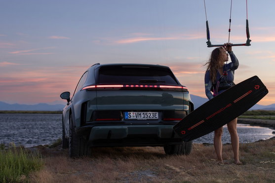 Planche de kitesurf twin-tip Duotone Jaime SLS Porsche Turbo Edition 136 cm en noir et rouge au coucher de soleil côtier