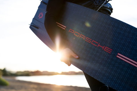 Duotone Jaime SLS Porsche Turbo Edition twin-tip kiteboard 136cm in dark charcoal and red during kitesurfing at the coast