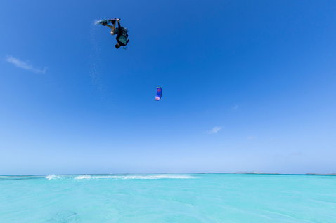 Duotone Dice SLS LEI kite during kitesurfing over a tropical lagoon with freestyle aerial trick
