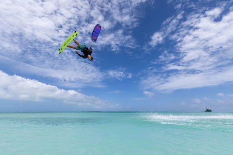 Duotone Dice SLS LEI kite during kitesurfing over a turquoise lagoon with inverted freestyle trick