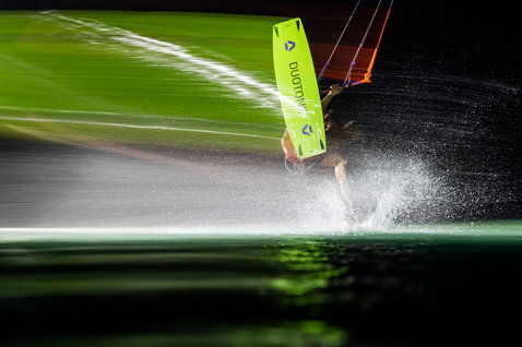 Duotone Dice SLS LEI kite during kitesurfing in neon yellow-green at night