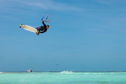 Duotone Dice SLS LEI kite during freestyle kitesurfing above a tropical turquoise lagoon