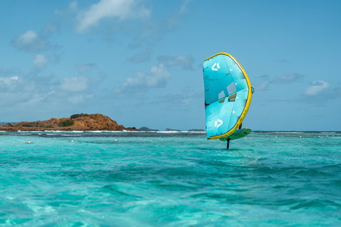 Ala foil Duotone Unit D/LAB durante il wing foiling su una laguna tropicale turchese