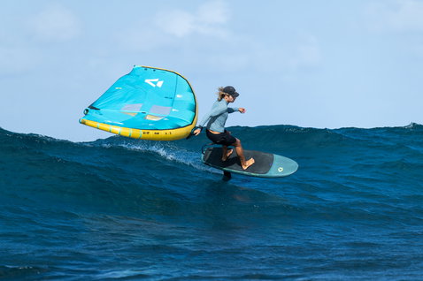 Duotone Unit D/LAB foil wing 4,5 m durante wing foiling su un'onda oceanica in turchese e giallo