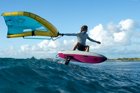 Duotone Unit D/LAB foil wing durante wing foiling sull'oceano tropicale in cyan e giallo
