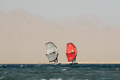 Duotone Unit SLS Foil Wing beim Wing Foiling auf dem Meer mit Wüstengebirge im Hintergrund