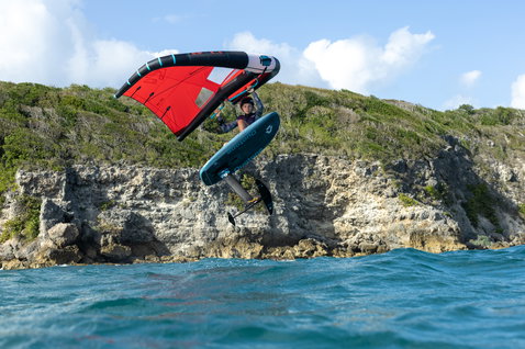 Duotone Unit SLS Foilwing beim Wing Foiling an der Felsküste von Guadeloupe in rot und türkis