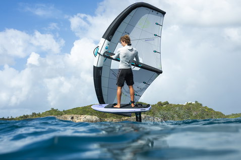 Duotone Unit Foilwing beim Wing Foiling im türkisblauen Meer vor einer grünen Insel in der Karibik