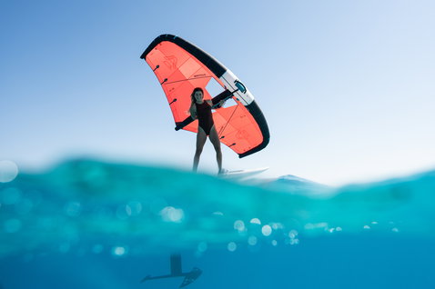 Duotone Unit Foilwing beim Wing Foiling auf dem Meer in koralle und schwarz