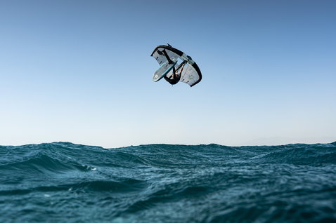 Duotone Unit SLS Foil Wing beim Wing Foiling mit Aerial-Freestyle-Manöver über dem Ozean
