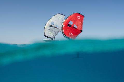 Duotone Unit Foil Wing beim Wing Foiling im türkisfarbenen Ozean, zwei Farben grau und rot