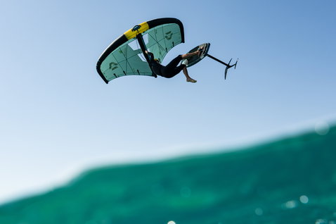 Duotone Unit SLS Foil Wing beim Wing Foiling mit Aerial Trick über türkisem Ozean