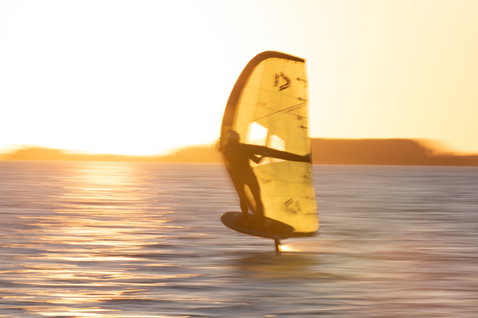 Duotone Unit SLS Foilwing beim Wing Foiling bei goldenem Abendlicht auf dem Meer