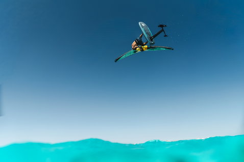 Duotone Sky Style SLS Foilboard beim Wing Foiling in der Luft über türkisem Meer