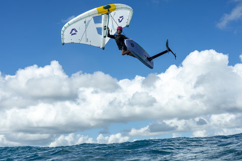 Planche de foil Duotone Sky Style en wing foiling avec athlète en l'air au-dessus de l'océan