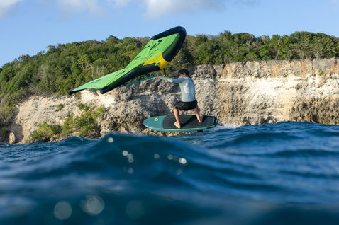 Planche de foil Duotone Skybrid SLS lors du wing foiling en côte tropicale en Guadeloupe en bleu marine