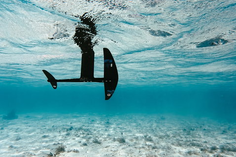 Duotone Crest SLS front wing during foiling in turquoise tropical shallow water