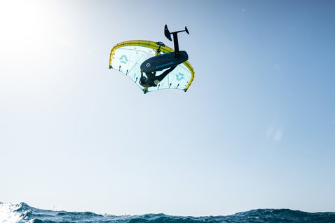 Duotone Unit D/LAB Frontwing beim Wing Foiling über dem Meer mit Rider im Freestyle-Aerial