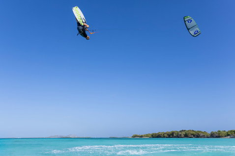Duotone Trust Bar quad control bar during Big Air kitesurfing above a turquoise tropical lagoon