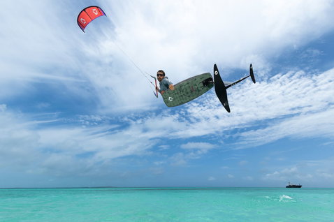 Duotone Soar SLS planche de kite foil en plein foiling au-dessus d'un océan turquoise