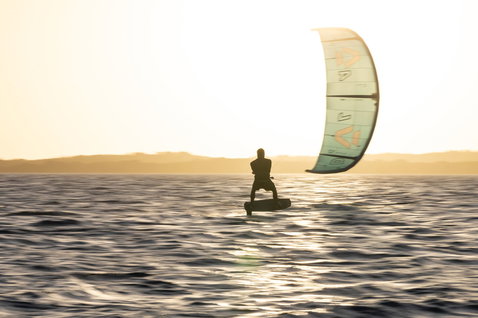 Duotone Soar SLS planche de foil en session de kite foiling sur l'océan au coucher du soleil
