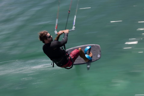 Planche de kite foil Duotone Soar SLS lors d'une session de kite foiling sur l'océan en vert foncé et carbone