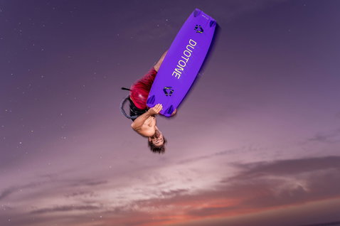 Tabla de kitesurf twin-tip Duotone Jaime SLS durante freestyle en cielo al atardecer en violeta
