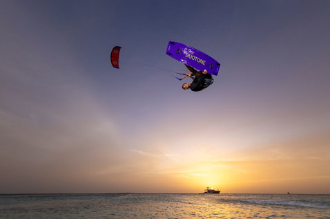 Tabla de kitesurf twin-tip Duotone Jaime SLS durante freestyle en el océano al atardecer