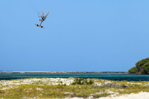 Tabla de kitesurf twin-tip Duotone Jaime SLS durante freestyle sobre una laguna tropical