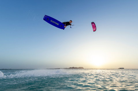 Tabla de kitesurf twin-tip Duotone Jaime SLS durante truco freestyle aéreo sobre el océano al atardecer
