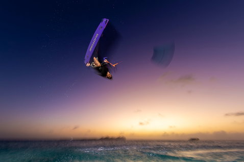 Tabla de kitesurf twin-tip Duotone Jaime SLS durante un truco aéreo de freestyle al atardecer sobre el mar