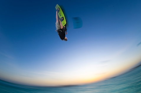 Tabla de kitesurf twin-tip Duotone Jaime Concept Blue durante freestyle en el océano al atardecer