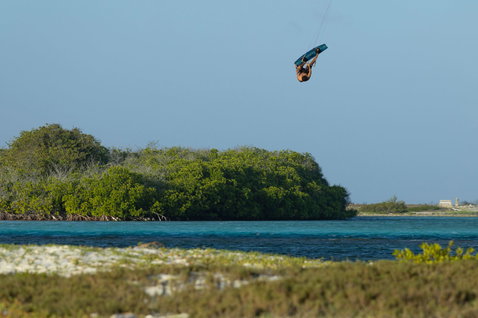 Tabla de kitesurf twin-tip Duotone Select SLS durante una sesión de kitesurf sobre una laguna tropical