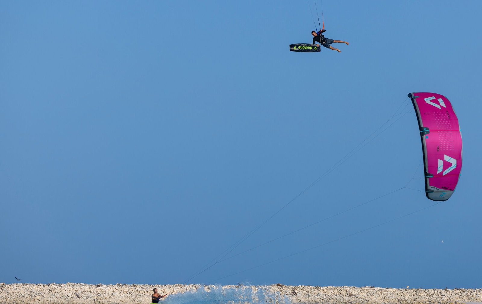 Duotone Select SLS twin-tip kiteboard during kitesurfing at the beach under clear blue sky